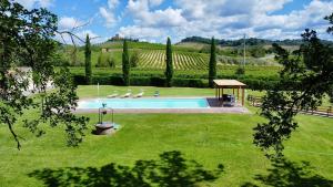 a swimming pool in a yard with trees and a field at Casale delle Querce in Orvieto