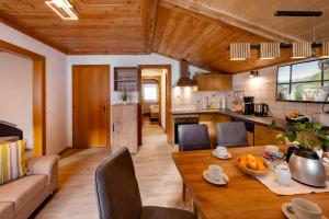 a kitchen and living room with a wooden table and chairs at Bauernhof Klausbauer in Grossarl