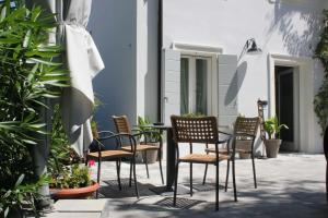 una mesa y sillas en un patio con plantas en Punto 41, en Peschiera del Garda