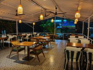 a restaurant with wooden tables and chairs and lights at Aurelia by Jackfruit in Arambol