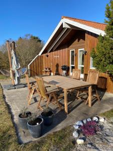 a picnic table and chairs in front of a cabin at Huset ved stranden in Nykøbing Sjælland