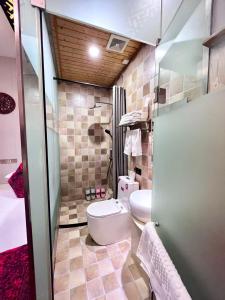 a bathroom with a toilet and a sink at Pingyao HongJingYuanGuesthouse in Pingyao