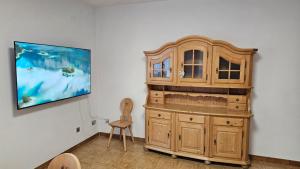 a large wooden cabinet in a room with a chair at Appartamenti Croz del Re 2 in Andalo