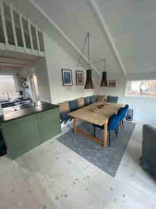 a kitchen and dining room with a wooden table and blue chairs at Huset ved stranden in Nykøbing Sjælland