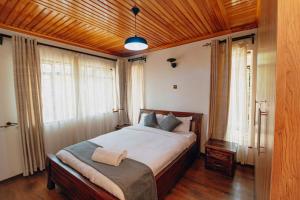 a bedroom with a large bed in a room with windows at Karen Crown 5BR Villa in Nairobi
