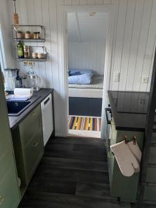 a small kitchen with a bed in a small room at Huset ved stranden in Nykøbing Sjælland