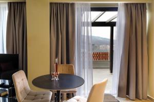 a dining room with a table and chairs and a window at Angels Riva Boutique Residences in Kastoria