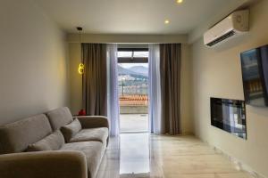 a living room with a couch and a sliding glass door at Angels Riva Boutique Residences in Kastoria