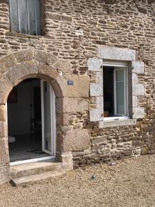 a stone building with two windows on it at Maisonnette de campagne in Val Couesnon