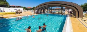 a group of people in a swimming pool at Mobilhome La Pause Océane - La Plage in Mimizan-Plage