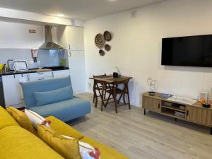 a living room with a yellow couch and a tv at Casa da Zéfinha - STUDIO in Cinfães