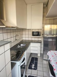 a kitchen with a sink and a stove top oven at Apto Completo com Conforto e Garagem Proximo a USP e HC in Ribeirão Preto