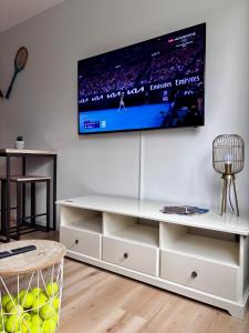 a living room with a tv on a wall at L'Open d'Australie in Chalon-sur-Saône