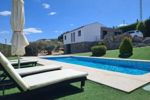 a swimming pool with a chaise lounge and an umbrella at The Douro Nest in Valença do Douro