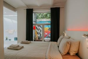 a bedroom with a large bed with a window at Luxury loft with private parking in Liège