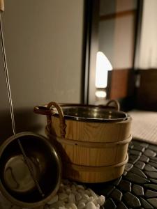 a wooden pot sitting on a table with a bowl at Heidi Guest House in Yuzawa