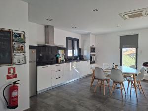 a kitchen with white cabinets and a table and chairs at The Douro Nest in Valença do Douro