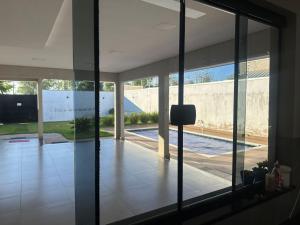 a view of a living room with glass doors at Moderna área com Wi-Fi e ar condicionado in Americana
