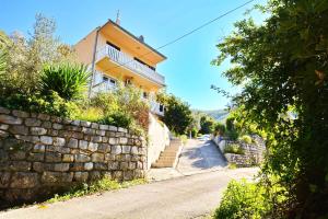 a stone wall next to a house on a street at Apartment Rita in Tivat