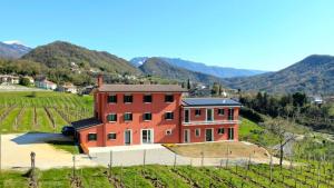 a house in a field with mountains in the background at Ca' Perenzin in Tarzo