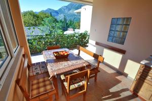 a dining room with a table and chairs and a large window at Apartment Rita in Tivat