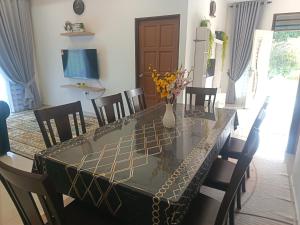 a dining room table with chairs and a vase with flowers at D'sawah Guest House in Kota Bharu