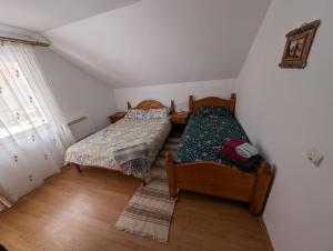 a bedroom with two beds and a window at Peste Vale in Poşaga de Sus