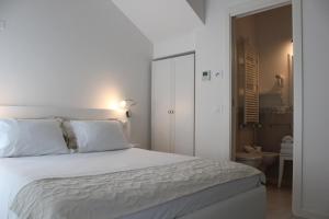 1 dormitorio con 1 cama blanca con sábanas y almohadas blancas en Punto 41, en Peschiera del Garda