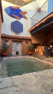 a swimming pool with surfboards on the side of a building at La Maison de Magdala in Ronda