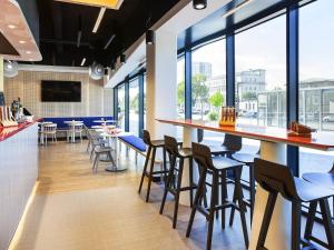 a bar in a restaurant with chairs and tables at Ibis Styles Mulhouse Centre Gare in Mulhouse