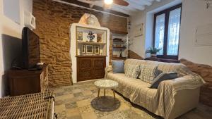 a living room with a couch and a stone wall at La Maison de Magdala in Ronda