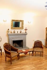 a living room with two chairs and a fireplace at Diuma 5 Guest house in Tbilisi City