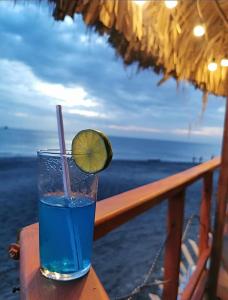a drink sitting on a table with a slice of lime at TAMA Hotel Santa Marta in Santa Marta