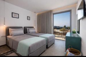 a bedroom with two beds and a large window at Private Villa Karydia with private pool in Zipárion +71 photos