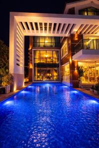 a swimming pool in front of a house at night at Villa Nuri Konaklama in Çiftlik