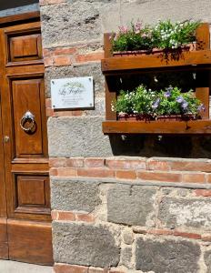 a brick wall with two flower boxes on it at La Foglia in Abbadia San Salvatore +95 photos
