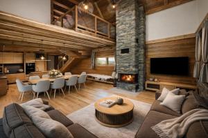 a living room with a couch and a table and a fireplace at Chalet Mountain Rock - Luxury retreat at Chalets Kvačianska dolina in Zuberec