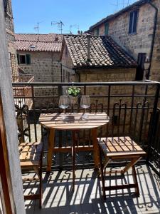 a table and chairs on a balcony with wine glasses at La Foglia in Abbadia San Salvatore