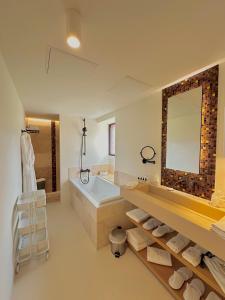 a bathroom with a tub and a large mirror at Aux ducs de Sienne in Montagne
