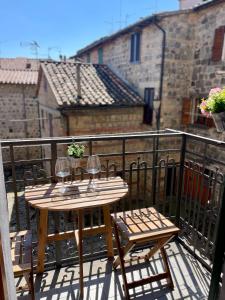 a wooden table and chairs on a balcony with a view at La Foglia in Abbadia San Salvatore