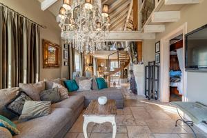 a living room with a couch and a chandelier at Le B Cottage & SPA Privé in Riquewihr
