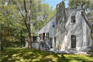 a gray house with a tree in a yard at Relaxing Beginnings in Cape May Point