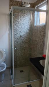 a bathroom with a shower with a toilet and a sink at Quartos Viracopos independente in Campinas