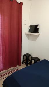 a room with a red curtain and two stools at Quartos Viracopos independente in Campinas