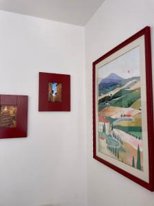 three pictures hanging on a white wall at La Foglia in Abbadia San Salvatore