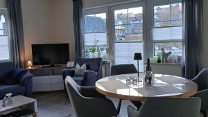 a living room with a table and chairs and a tv at Sommerwind am Kurgarten in Willingen