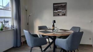 a dining room table with chairs and a bottle of wine at Sommerwind am Kurgarten in Willingen