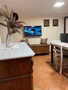 a living room with a table and a tv on the wall at Casa San Rocco in Busalla