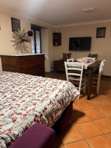 a bedroom with a bed and a table and a television at Casa San Rocco in Busalla