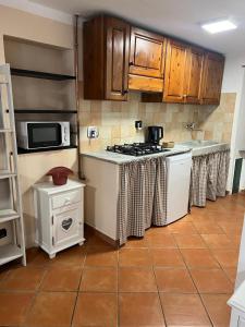 a kitchen with a stove and a microwave at Casa San Rocco in Busalla